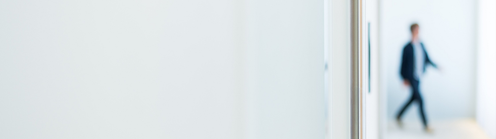 Office a man walks along a corridor towards a meeting room