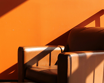 Brown leather armchair in front of orange wall